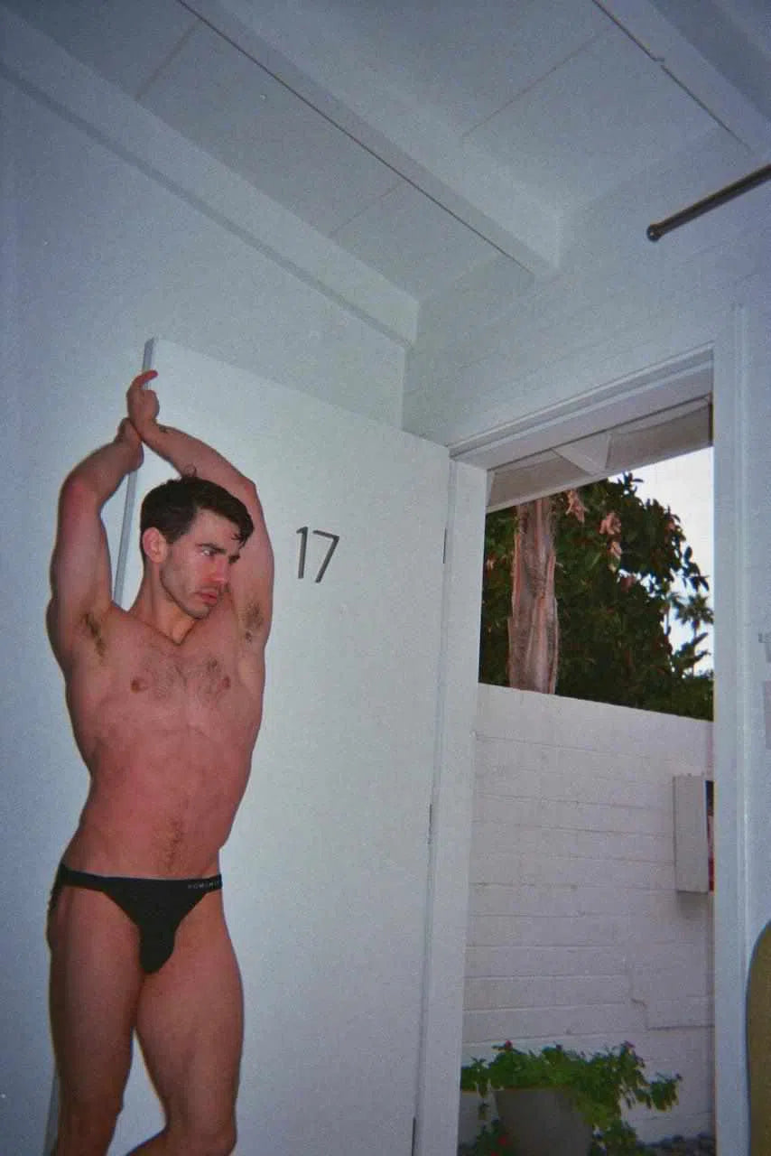 Model posing in doorway wearing black sport brief underwear